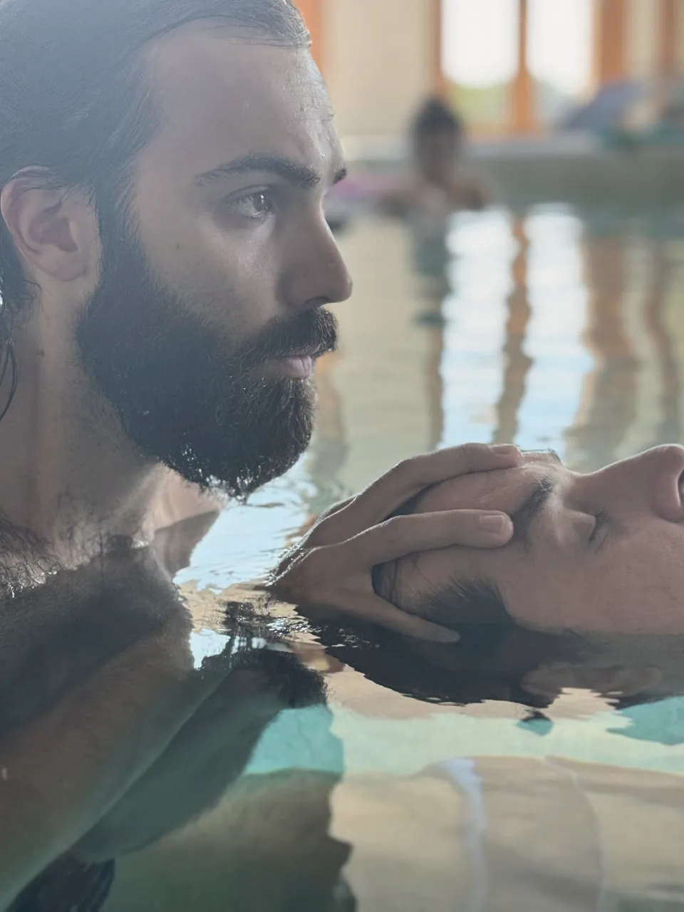 Alessandro in acqua sostiene con le mani la testa di una persona che galleggia a occhi chiusi