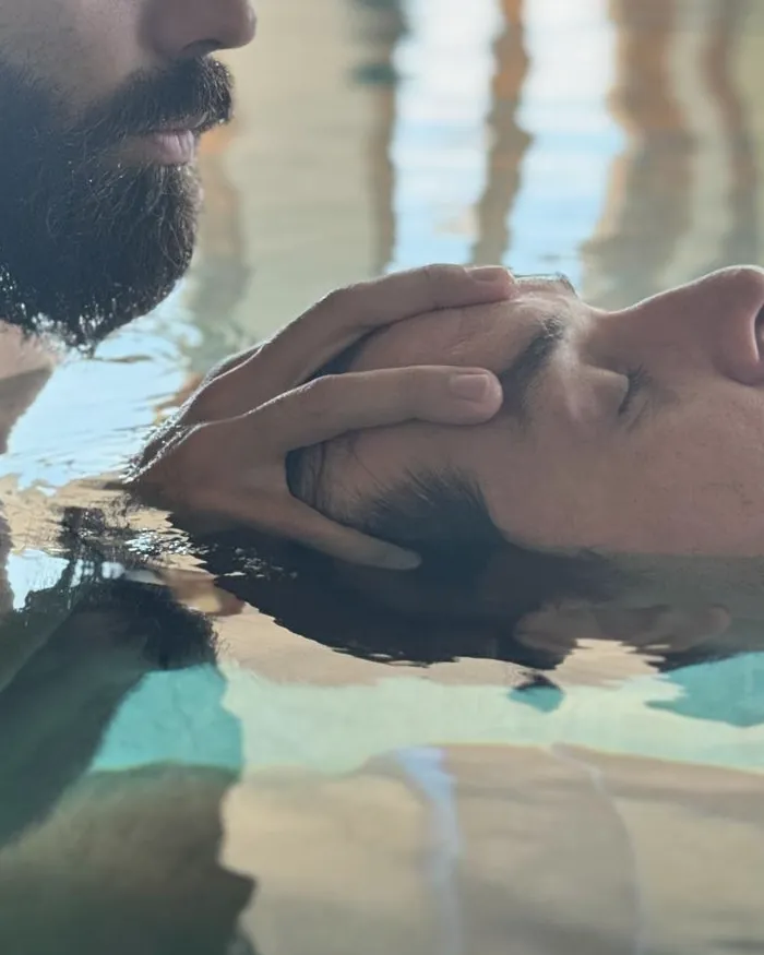 Le mani di Alessandro sostengono la testa di una persona che galleggia in acqua